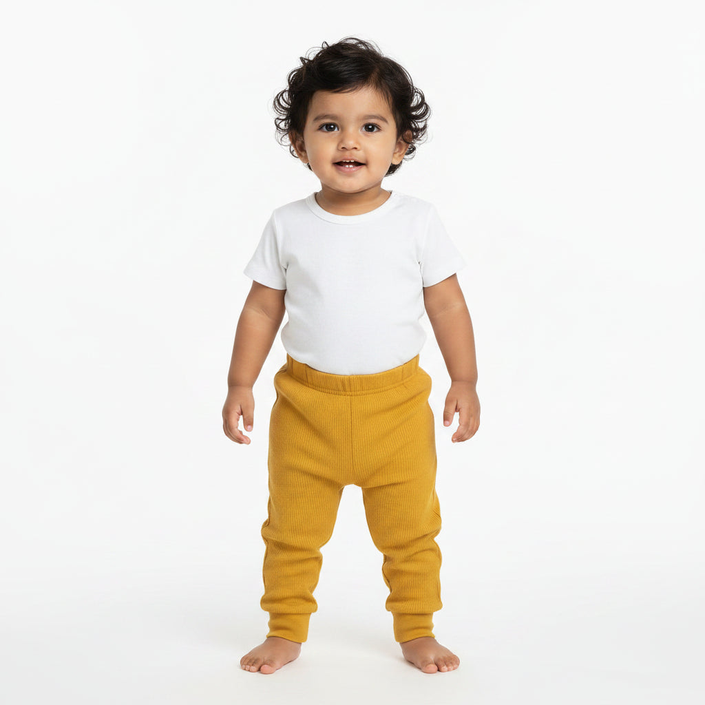 Mustard yellow sweatpants on a gray background