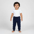 Navy blue baby pants with wooden buttons on a light gray background